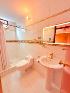 a white bathroom with a sink and a toilet at Hostel Sillustani Inn Puno - Con Cochera in Puno +48 photos