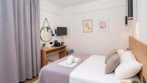 a white bedroom with a bed with white pillows at Lunar Hotel Modern Boutique in Hersonissos +46 photos