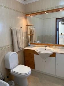 a bathroom with a toilet and a sink and a mirror at Esteves Apartment - Alvor Center in Alvor +29 photos
