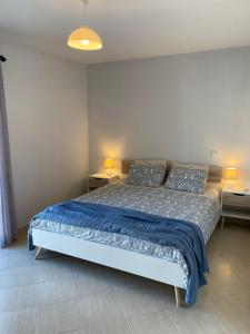 a bedroom with a bed with blue sheets and two tables at Esteves Apartment - Alvor Center in Alvor