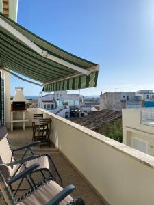a balcony with chairs and a piano on a roof at Esteves Apartment - Alvor Center in Alvor