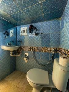 a blue bathroom with a toilet and a sink at Dar AL BARAKA in Tangier