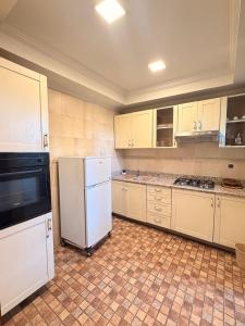 a kitchen with white appliances and a tiled floor at إقامة أطلس جيليز in Oulad Akkou