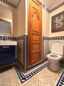 a bathroom with a toilet and a wooden door at إقامة أطلس جيليز in Oulad Akkou +2 photos