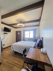 a bedroom with a bed and a table and chairs at Dawson House Lodge in Chemult