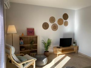 a living room with a tv and a chair at Esteves Apartment - Alvor Center in Alvor