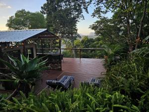 a wooden deck with two chairs and a gazebo at Clouds Serenity in Beechmont +38 photos