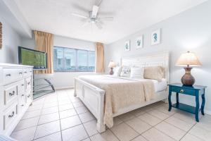 a white bedroom with a bed and a window at Sandcastles - Cocoa Beach Oceanfront Condos with Heated Pool Tennis in Cocoa Beach