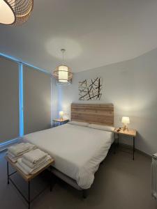 a bedroom with a large white bed and two tables at HOTEL RURAL Casa Campo in Abay
