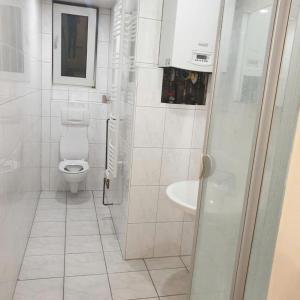 a white bathroom with a toilet and a sink at Wohngemeinschaft mit Privatzimmern in Niederdorla
