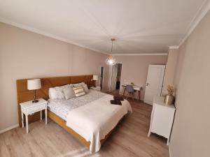 a bedroom with a large bed and two tables at Diamante house com garagem privada in Braga
