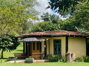 a small house with two benches in a yard at Hotel Santa Esmeralda in Bonito