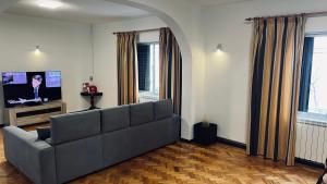 a living room with a couch and a flat screen tv at Villa do Monte in Porto Moniz