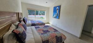 a bedroom with two beds and a window at Casa Velero in Puerto Vallarta