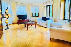 a living room with a couch and a tv at Hotel Punta Me Torreblanca Palace in Guadarrama