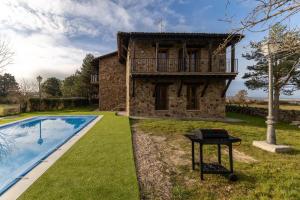 a stone house with a balcony and a swimming pool at Punta Me Mansion De Gallegos in Gallegos