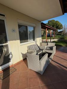 a patio with wicker furniture on a house at Paradise Coast House in Orfánion