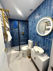 a blue tiled bathroom with a toilet and a sink at Chinatown Luxury Apartment in Madrid