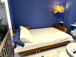 a bed in a room with a blue wall at Chinatown Luxury Apartment in Madrid +7 photos