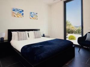 a bedroom with a large bed and a large window at Exclusive Stunning Views Pool in Road Town