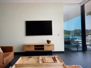 a living room with a tv and a chessboard on a table at Exclusive Stunning Views Pool in Road Town