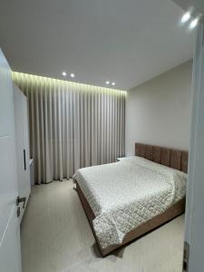 a bedroom with a bed and a large window at Aron apartments in Tirana