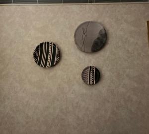 two black and white objects on a wall with a mirror at Hotel yes in Jaipur