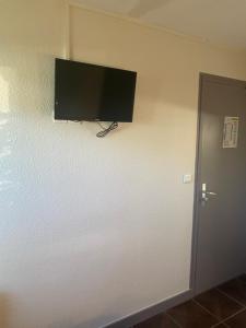 a flat screen tv on a wall next to a door at Fast hôtel Troyes in Barberey-Saint-Sulpice