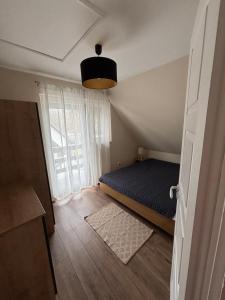 a small bedroom with a bed and a window at JanBar Apartman in Bük