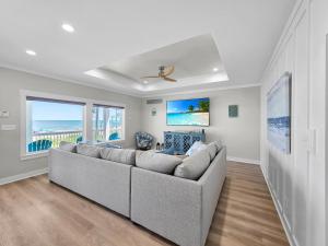 a living room with a large couch and windows at Blue Anchor home in Crystal Beach
