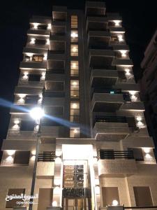 two tall buildings at night with a street light at شقة أنيقة-غرفتين وصالة مع بلكونة Stylish 2-Bedroom Apartment with Balcony in Amman