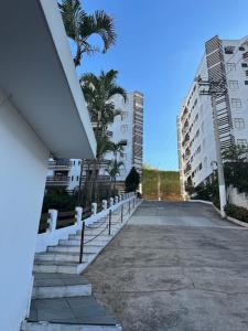 an empty street with palm trees and buildings at Apto a 3 quadras do centro, 2 quartos lazer comp in Serra Negra