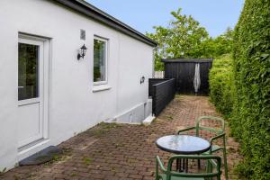a patio with a table and chairs next to a building at Skovhus 2-room Basement Apartment in Aarhus
