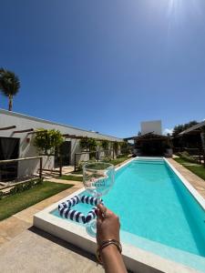 a person holding a wine glass in front of a swimming pool at Francisco Jonas de Oliveira in Itapipoca