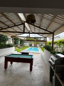 a ping pong table in a backyard with a pool at Francisco Jonas de Oliveira in Itapipoca