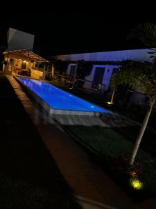 a blue swimming pool at night with a house at Francisco Jonas de Oliveira in Itapipoca