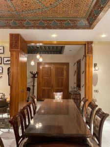 a dining room with a wooden table and chairs at Dar Ghita in Arrouaïs