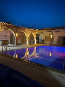 a large swimming pool in a building with a lit up at Dar Ghita in Arrouaïs
