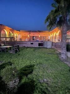 a building with a picnic table in the grass at Dar Ghita in Arrouaïs