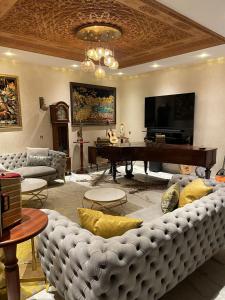 a living room with a couch and a piano at Dar Ghita in Arrouaïs