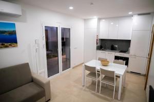 a kitchen with a white table and chairs and a couch at Casa Veigas in Macedo de Cavaleiros
