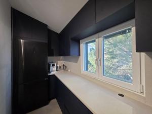a kitchen with black cabinets and a window at AiZ in Kastel Stafilic +24 photos