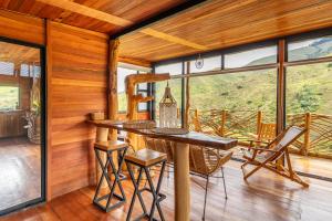 a dining room with a table and chairs on a porch at Mandrake Cabaña Nutria in Urrao