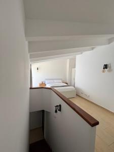 a small white room with a bed on a ledge at Apartamentos QEli in Son Carrio
