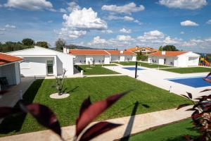 a courtyard with a yard with grass and houses at Casa Refúgio da Natureza in Macedo de Cavaleiros