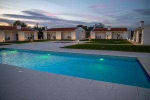 a swimming pool in front of a house at Casa Refúgio da Natureza in Macedo de Cavaleiros