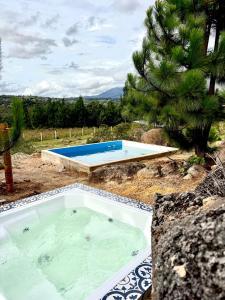 a hot tub in a yard with two swimming pools at AWA ECO GlAMPING SPA in Villa de Leyva