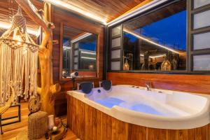 a large tub in a room with windows at Mandrake Cabaña Nutria in Urrao