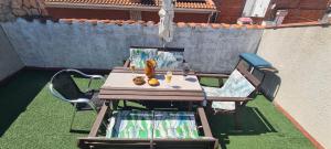 a table and chairs on a lawn with a fence at Can Tete in Malgrat de Mar
