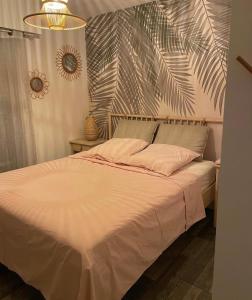 a bedroom with a large bed with a plant on the wall at Vacances in Cavalaire-sur-Mer